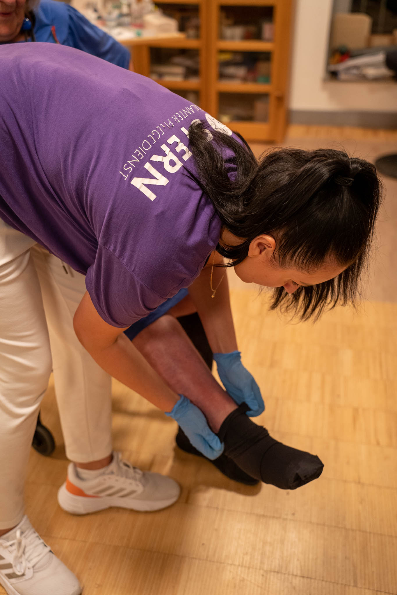 Pflegefachkraft wechselt Strümpfe